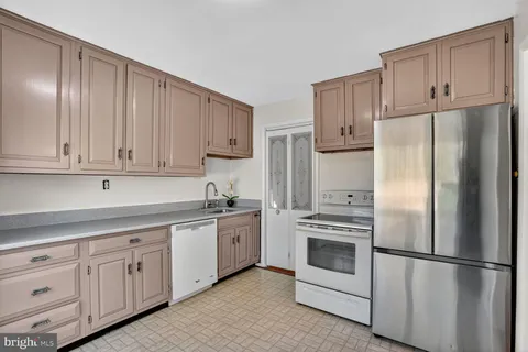 a kitchen with cabinets stainless steel appliances and a counter space