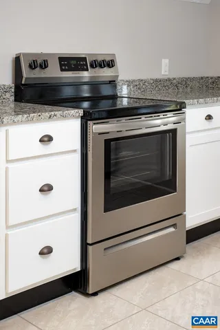 a kitchen with stainless steel appliances granite countertop a toilet a sink and a refrigerator