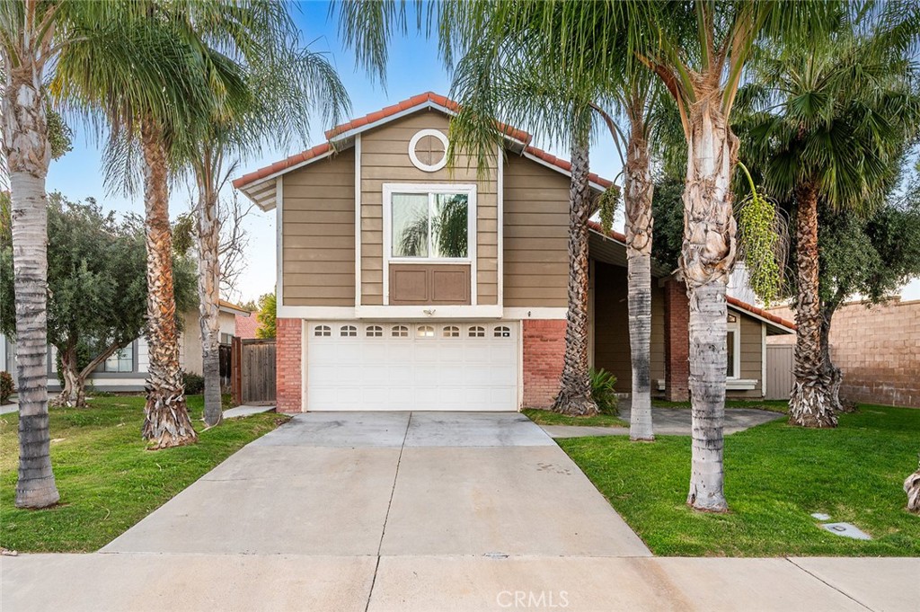 front view of house with a yard and palm trees