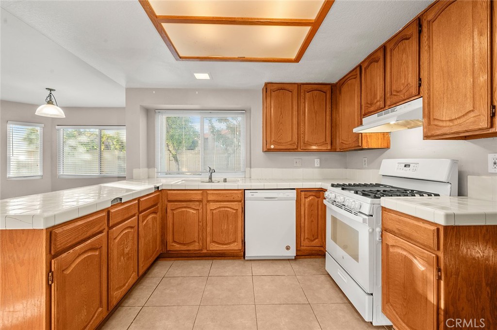 31348 Huron Street Temecula, CA 92592 - Photo 12 of 46 a kitchen with stainless steel appliances granite countertop a stove sink and cabinets