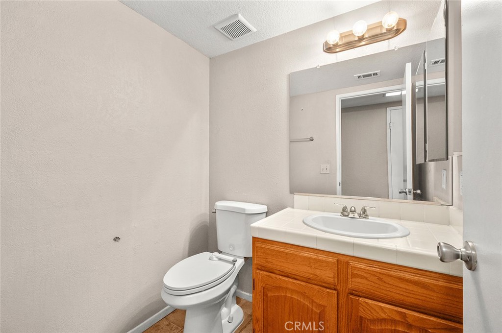 31348 Huron Street Temecula, CA 92592 - Photo 18 of 46 a bathroom with a sink a toilet and a mirror