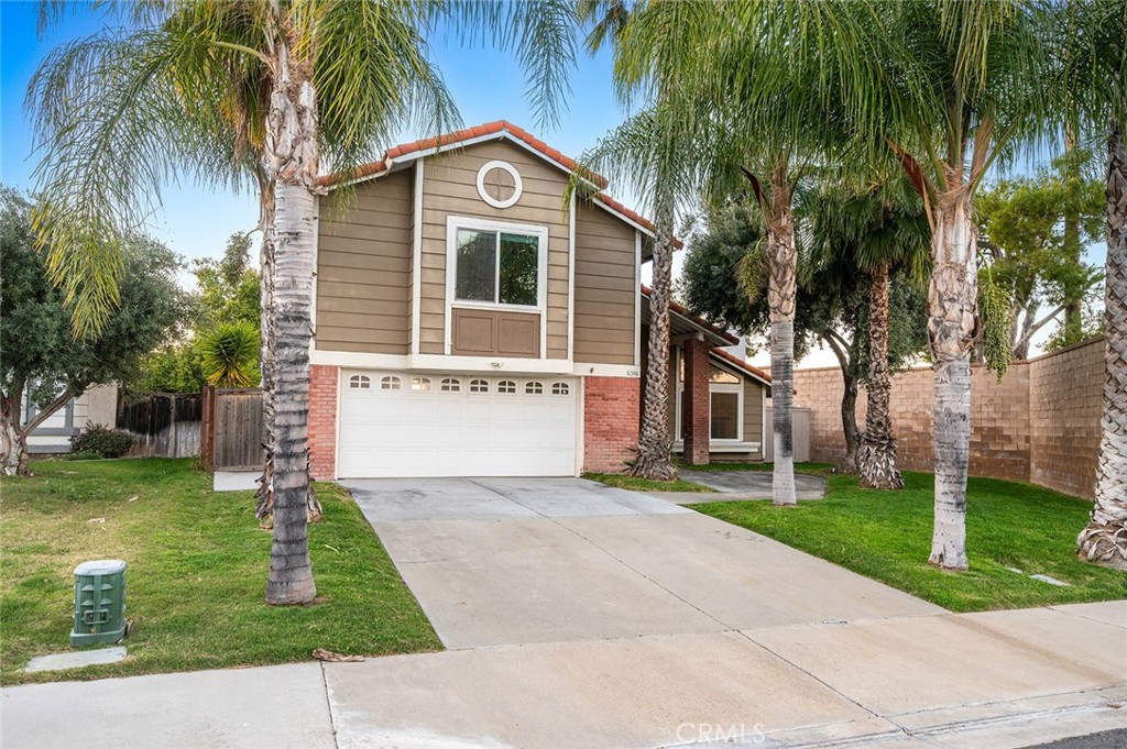 31348 Huron Street Temecula, CA 92592 - Photo 2 of 46 a front view of a house with a yard and palm trees