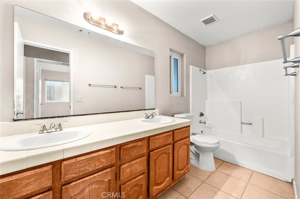 31348 Huron Street Temecula, CA 92592 - Photo 30 of 46 a bathroom with a double vanity sink toilet mirror and bathtub