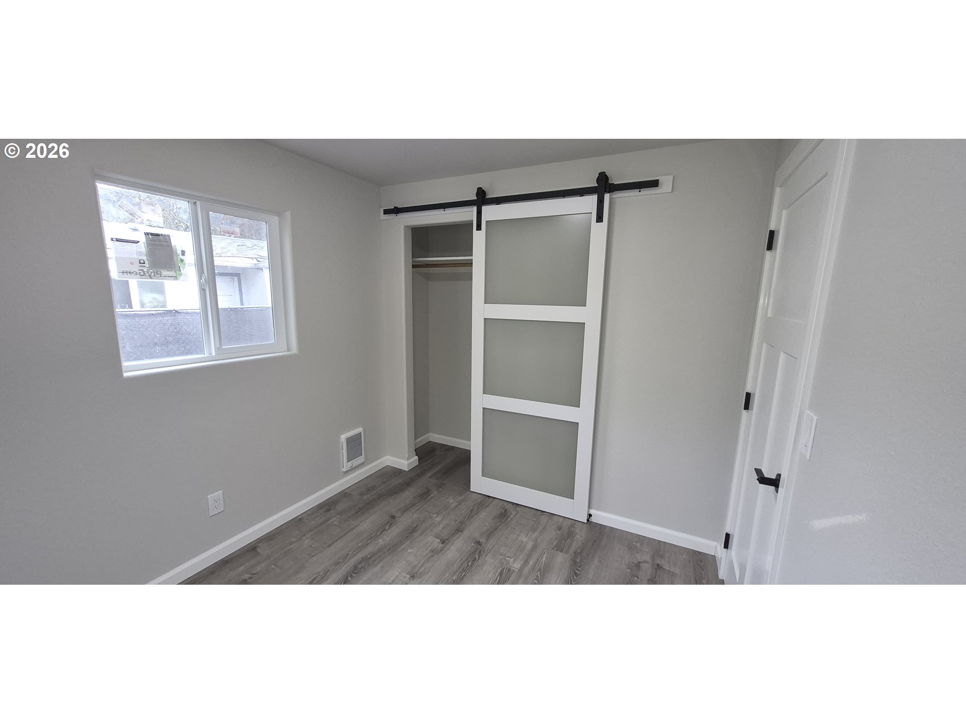 119 Walnut Street Myrtle Creek, OR 97457 - Photo 6 of 10 a view of an empty room with wooden floor and a window