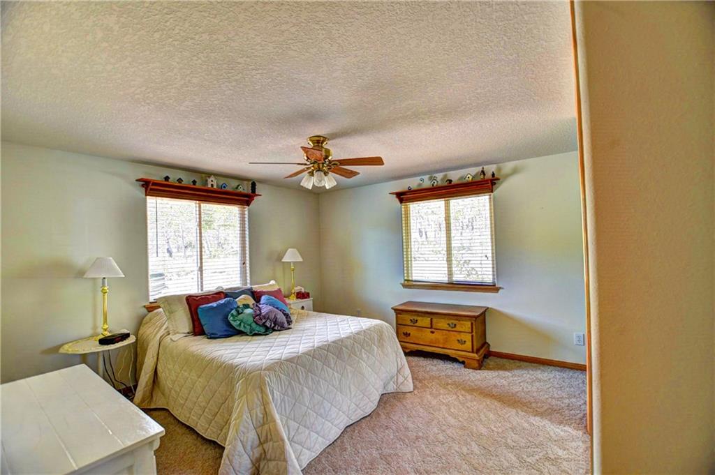 293 Old Squaw Road Como, CO 80432 - Photo 19 of 21 a bedroom with a bed and a chandelier