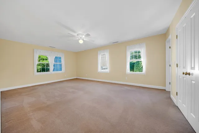 an empty room with windows and closet