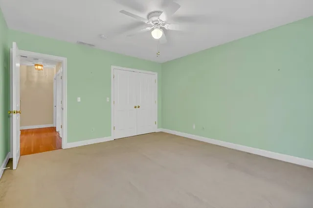 an empty room with closet and a chandelier fan