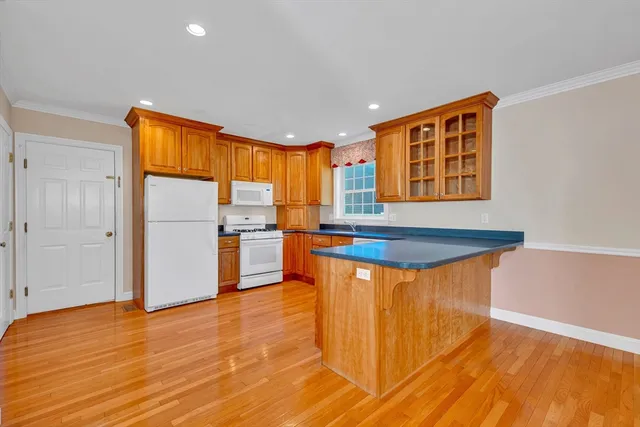 a kitchen with stainless steel appliances granite countertop a refrigerator a sink dishwasher and a stove with wooden floor