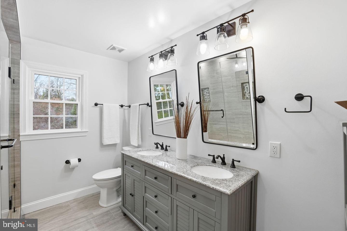8436 Burning Tree Road Bethesda, MD 20817 - Photo 14 of 33 a bathroom with a double vanity sink mirror and toilet