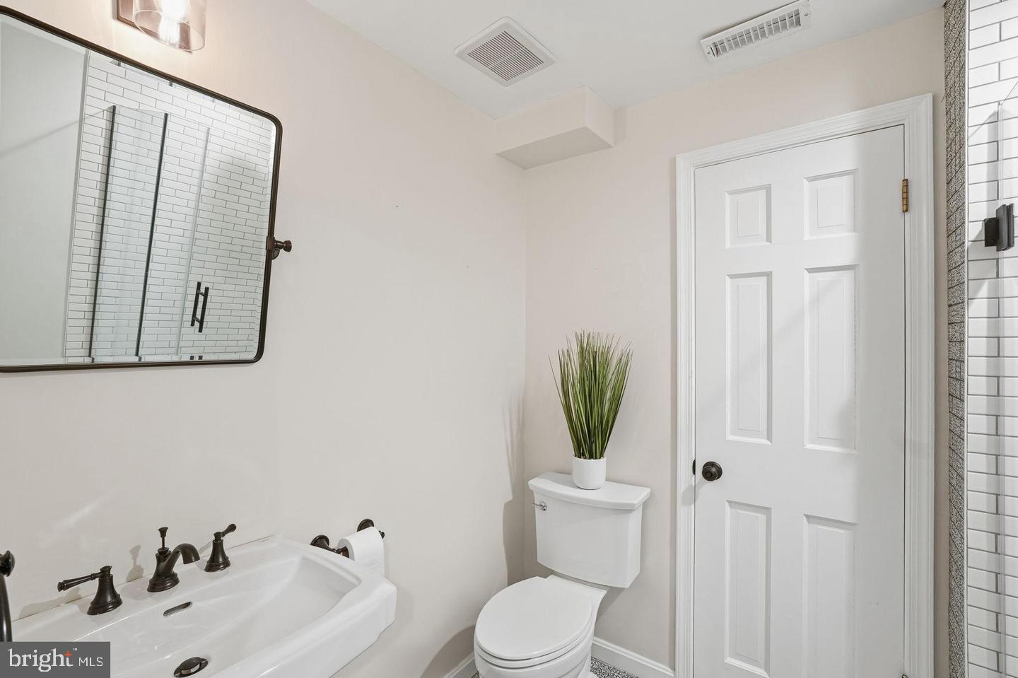 8436 Burning Tree Road Bethesda, MD 20817 - Photo 23 of 33 a bathroom with a toilet sink and mirror
