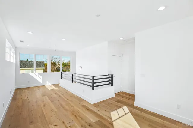 a view of a bedroom with wooden floor and windows