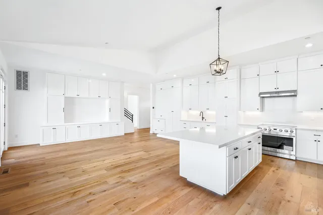 a large white kitchen with a large stove top oven and white cabinets