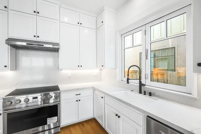 a kitchen with stainless steel appliances a stove sink and cabinets