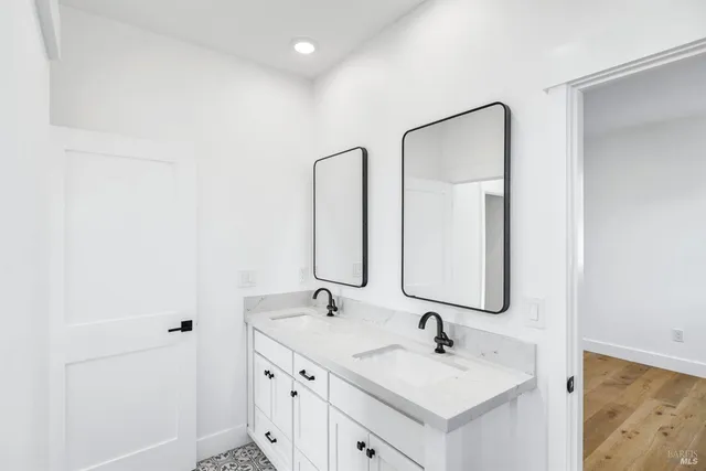 a bathroom with a double vanity sink and a mirror