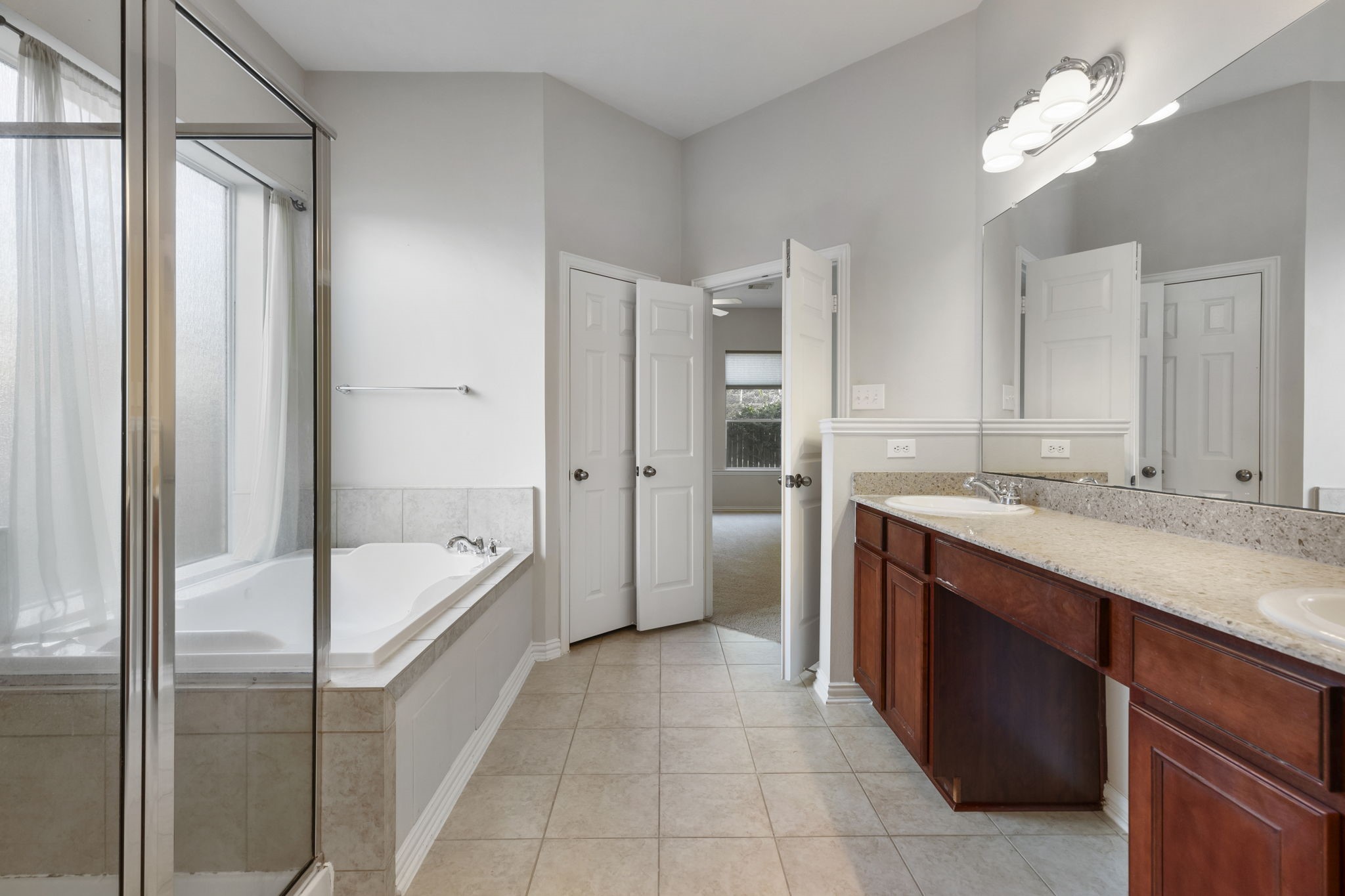 80 West Frontera Circle Spring, TX 77382 - Photo 15 of 28 En-suite features a large jetted tub, a separate glass-enclosed shower, and a double sink vanity with storage.