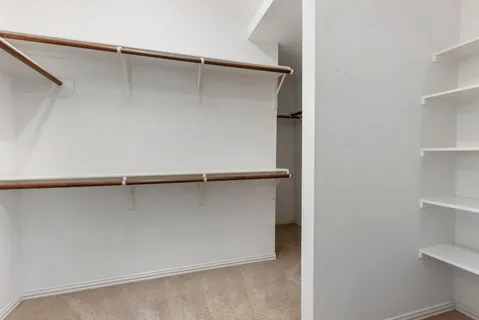 a view of walk in closet with empty racks