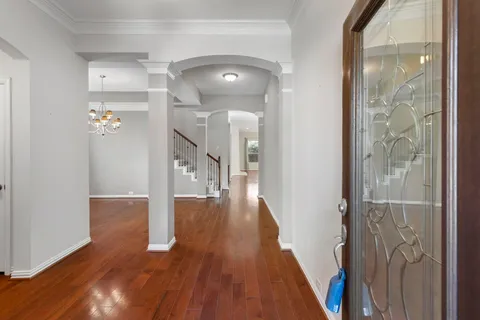 a view of a hallway with wooden floor and staircase