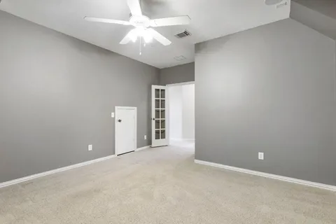 en empty room with a ceiling fan and window