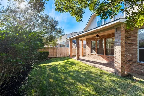 a view of a house with backyard and sitting area