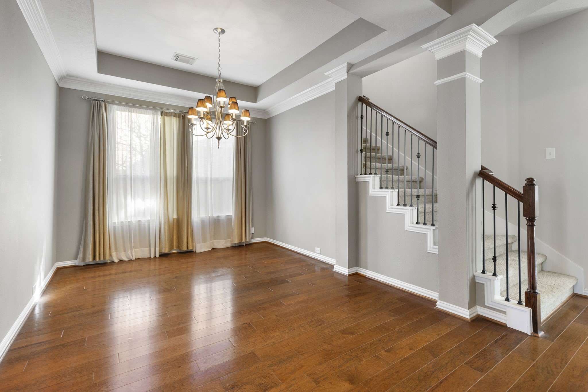 80 West Frontera Circle Spring, TX 77382 - Photo 5 of 28 This photo showcases an open dining area with hardwood floors, a stylish chandelier, and an abundance of natural light