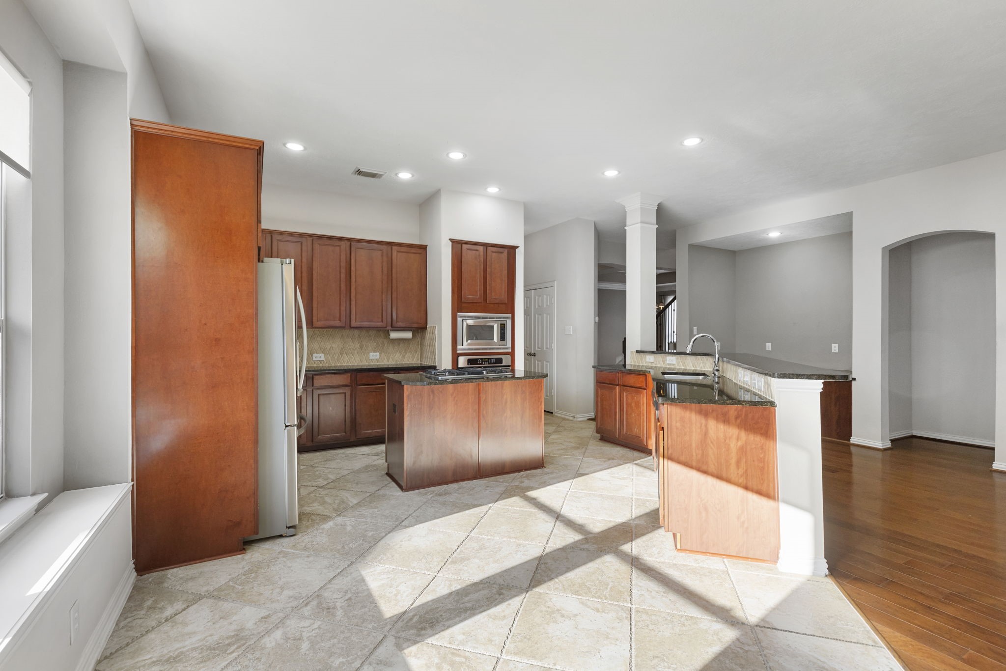 80 West Frontera Circle Spring, TX 77382 - Photo 6 of 28 This spacious kitchen features sleek wooden cabinets, modern stainless steel appliances, and a central island. Ample natural light, and an open layout ideal for entertaining.