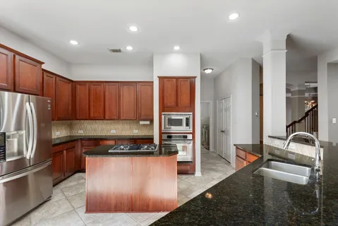 a kitchen with stainless steel appliances granite countertop a refrigerator and a sink