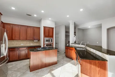 a kitchen with stainless steel appliances granite countertop a sink stove and cabinets