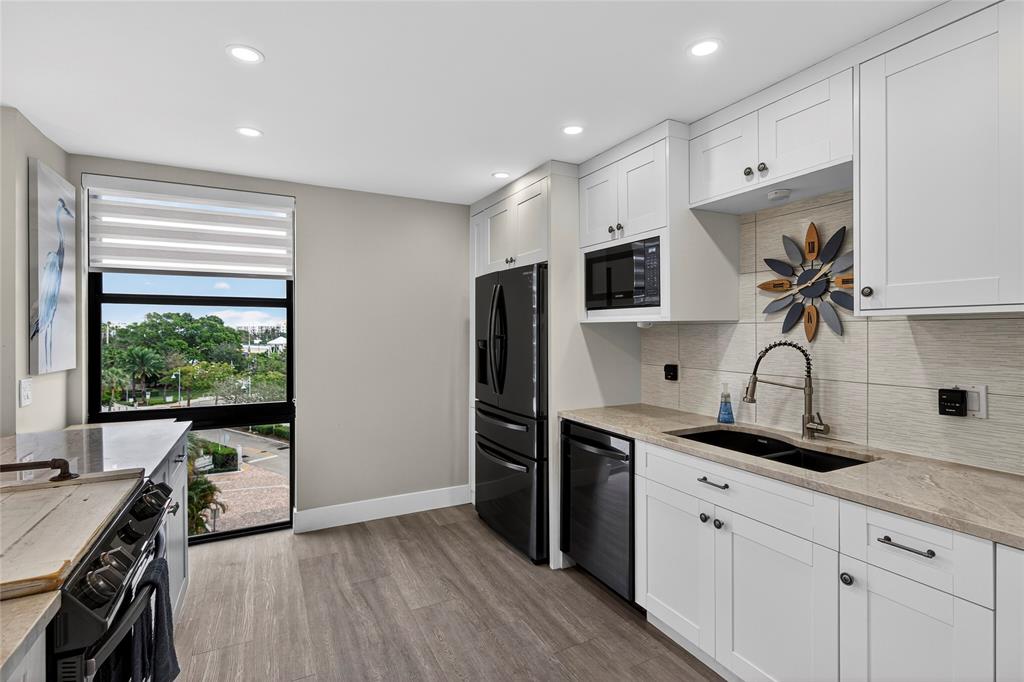 1629 Riverview Road, Unit 521 Deerfield Beach, FL 33441 - Photo 30 of 54 a kitchen with stainless steel appliances a stove sink and refrigerator