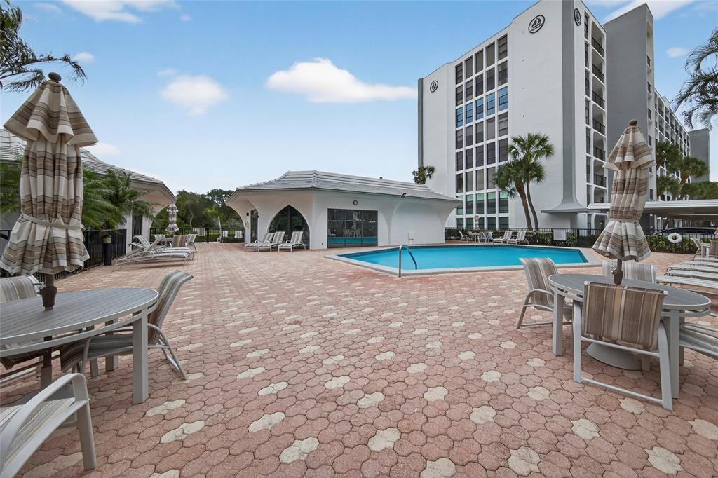 1629 Riverview Road, Unit 521 Deerfield Beach, FL 33441 - Photo 42 of 54 a swimming pool with outdoor seating and yard