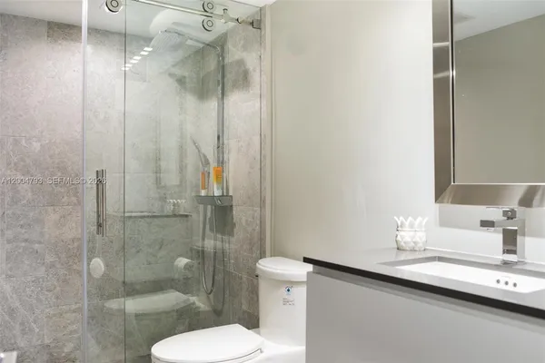 a bathroom with a sink a toilet and shower