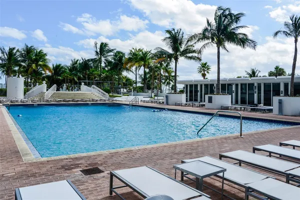 a view of a house with pool and chairs