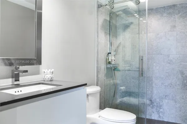 a bathroom with a sink a toilet and shower