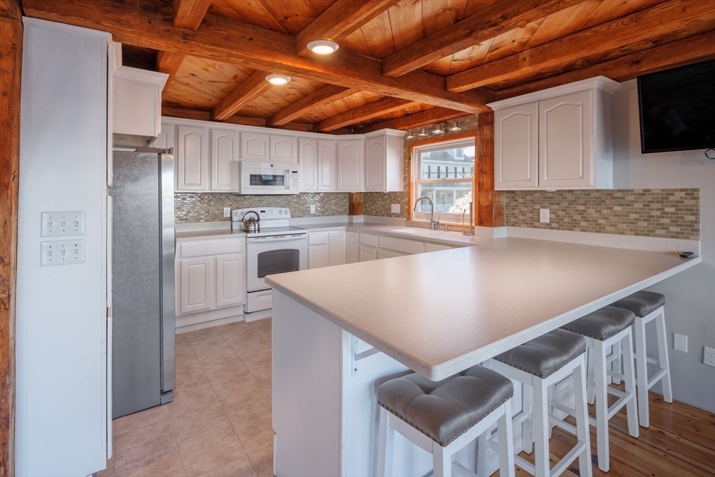 71 Willow Road Nahant, MA 01908 - Photo 14 of 30 a kitchen with stainless steel appliances granite countertop a sink a stove and a refrigerator