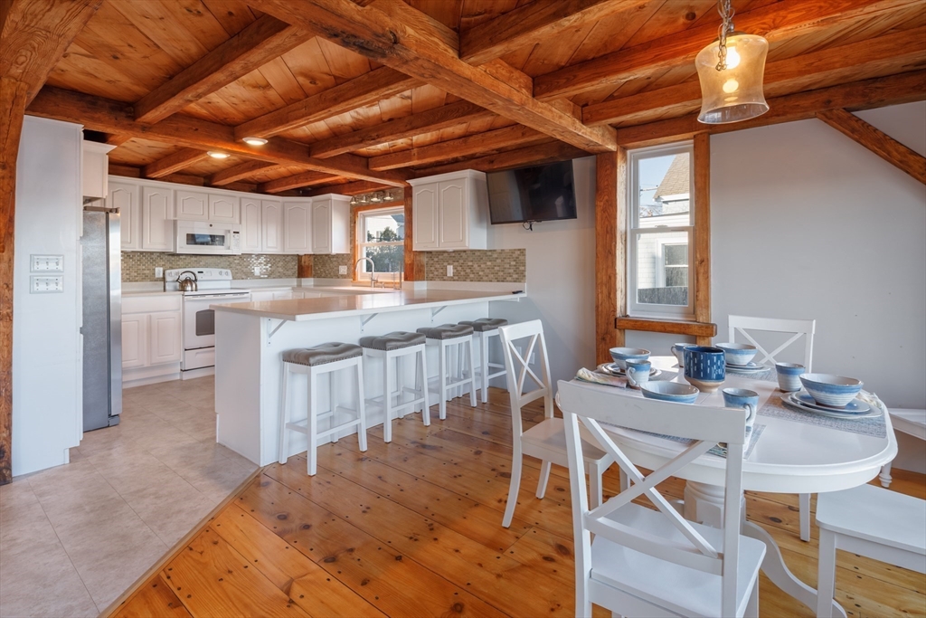 71 Willow Road Nahant, MA 01908 - Photo 16 of 30 a kitchen with kitchen island a stove a table and chairs in it