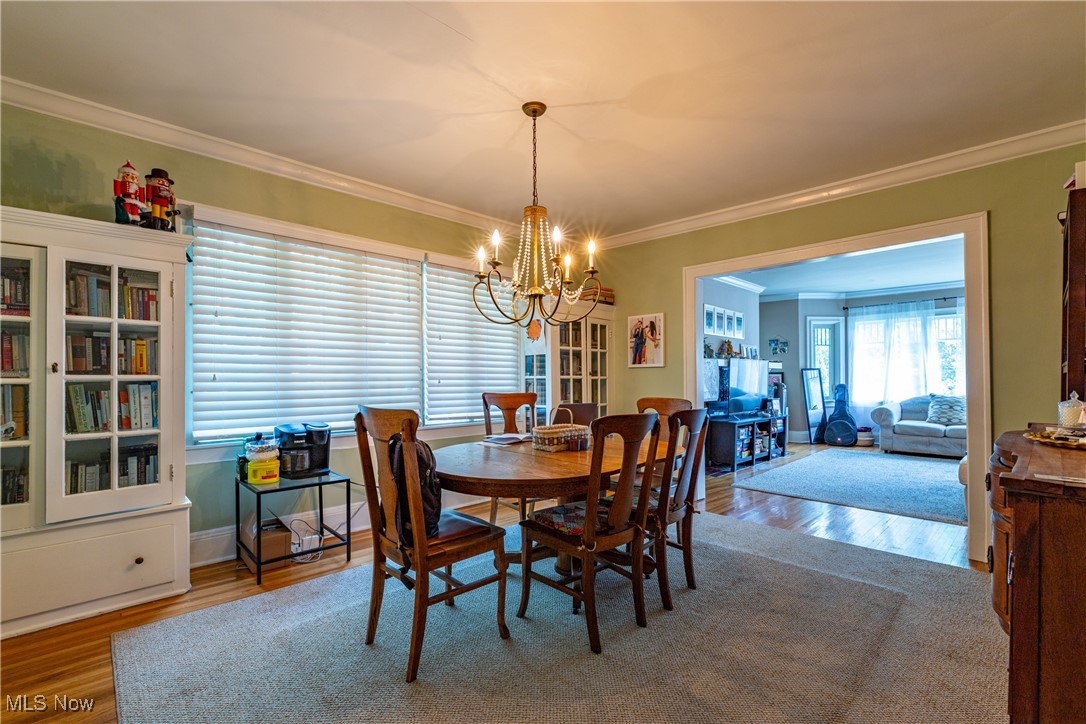 3232 Clarendon Road Cleveland, OH 44118 - Photo 8 of 22 Dining room with hardwood / wood-style flooring, a notable chandelier, and ornamental molding