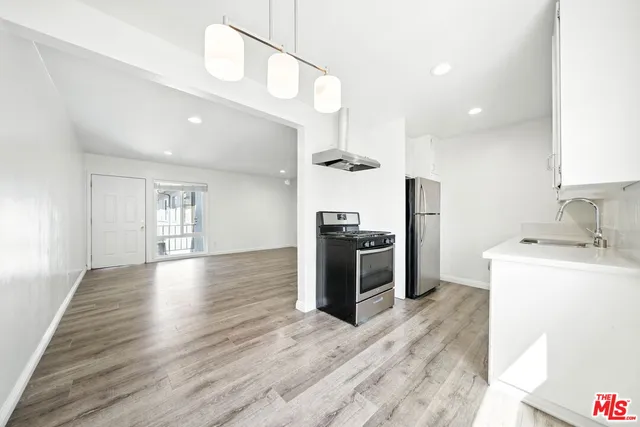 a view of a kitchen with a sink and a refrigerator