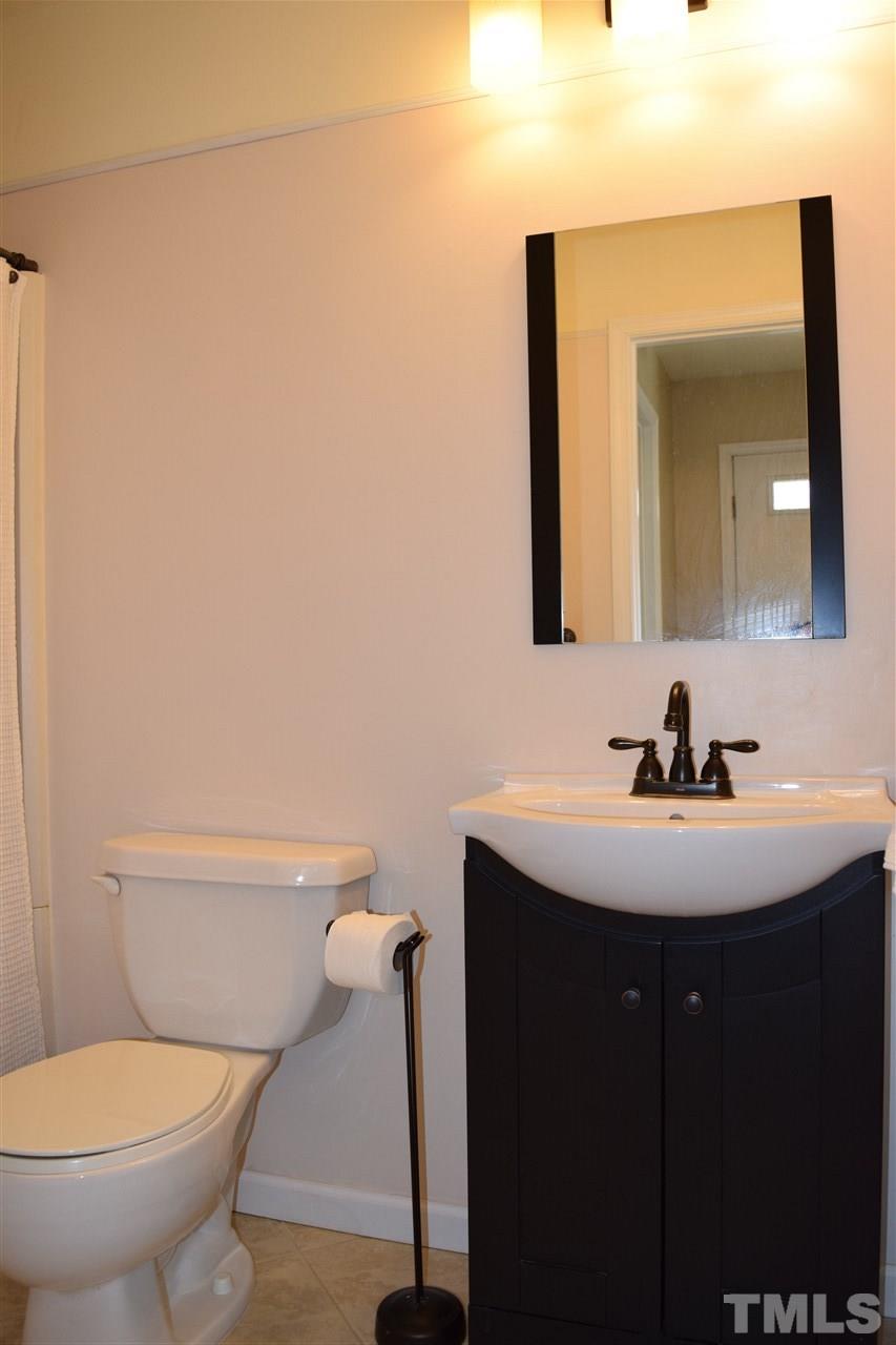 4404 Lake Ridge Drive Raleigh, NC 27604 - Photo 24 of 24 a bathroom with a toilet sink and mirror