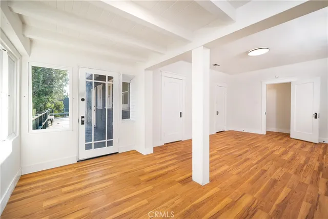 a view of empty room with wooden floor and fan