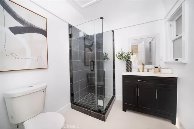 a bathroom with a shower sink vanity mirror and toilet