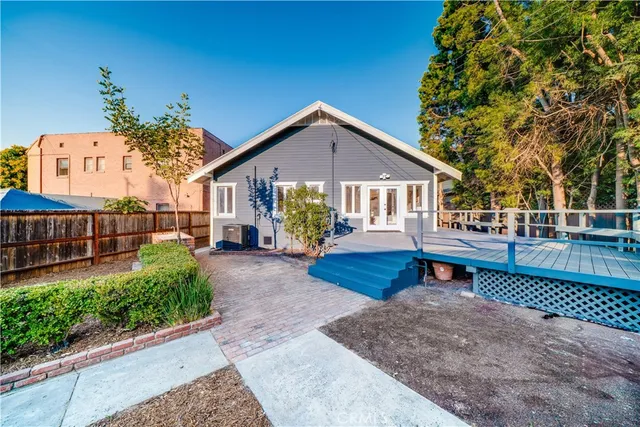 a view of a house with wooden deck and furniture