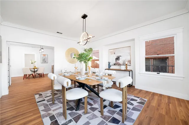 a view of a dining room and livingroom with furniture wooden floor a chandelier