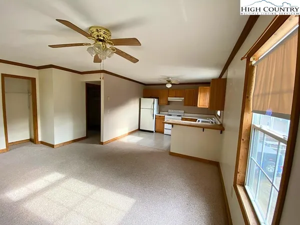 a view of a kitchen with a sink and dishwasher a refrigerator with wooden floor