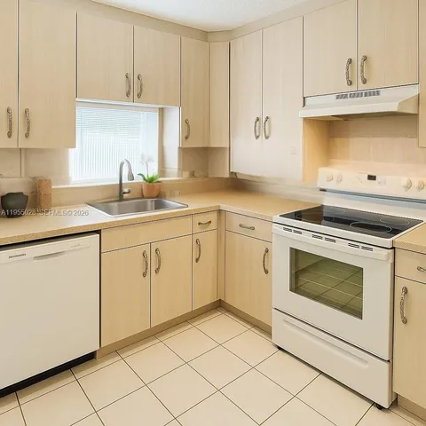 a kitchen with cabinets appliances and a sink
