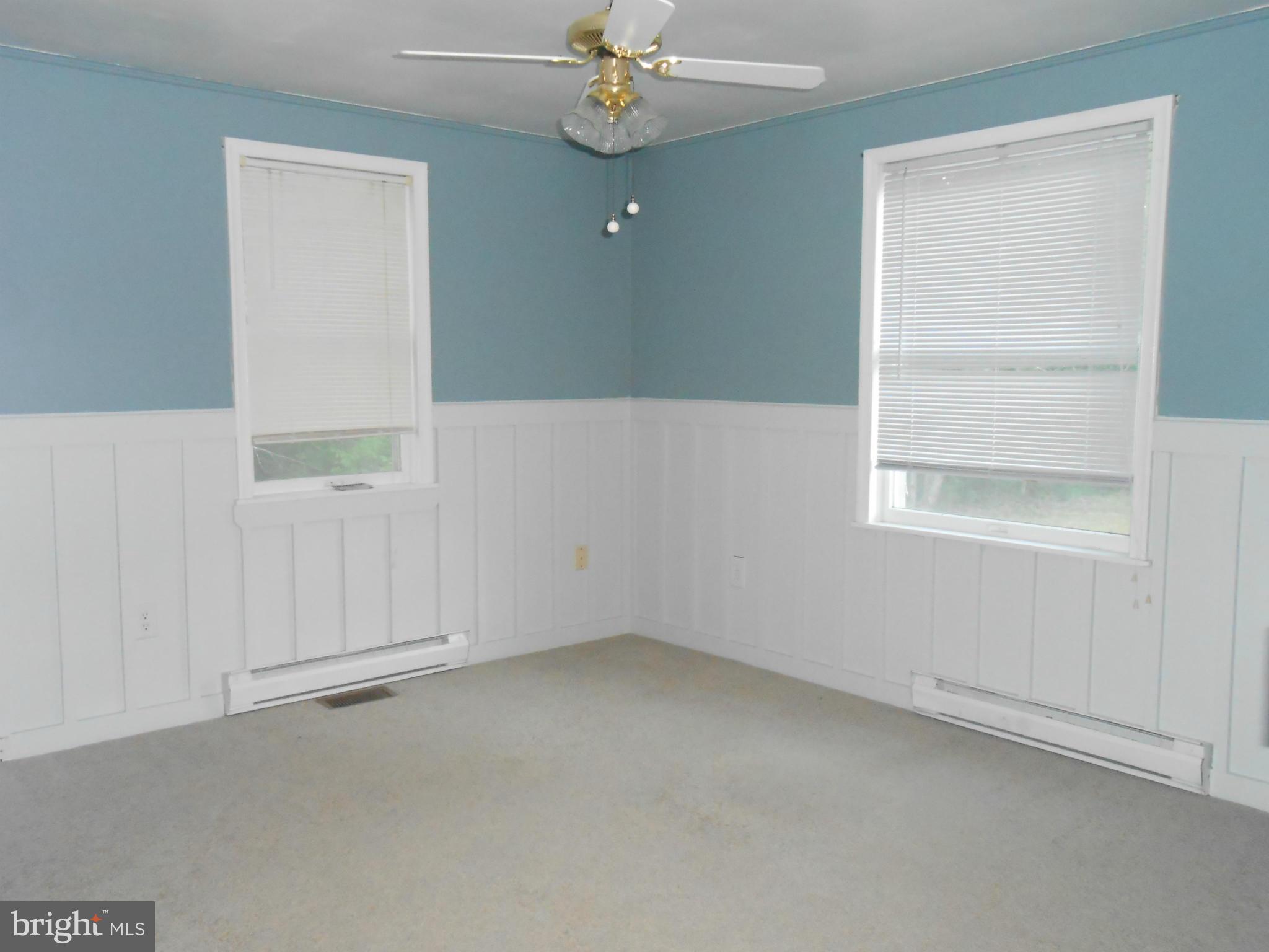 18111 Three Notch Road Lexington Park, MD 20653 - Photo 8 of 23 an empty room with a chandelier fan and windows