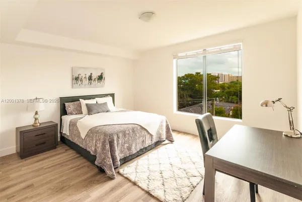 a bedroom with a bed and a large window