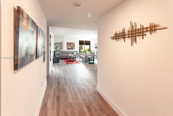 a hallway with a wooden floor and a table