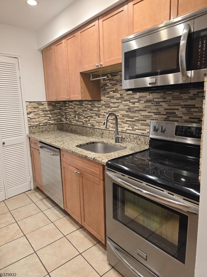 2350 Route 10 Morris Plains, Unit D14 Morris Plains, NJ 07950 - Photo 8 of 13 a kitchen with granite countertop a stove microwave and sink