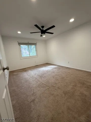 a view of a livingroom with a ceiling fan and wooden floor