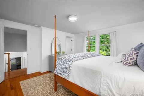 a bedroom with a bed and a dresser next to a window