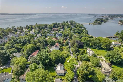 an aerial view of a houses with a yard and lake view